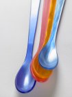 Primo piano vista di cucchiai di plastica colorata sulla superficie bianca — Foto stock
