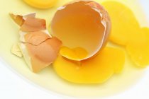 Huevo roto con yema - foto de stock