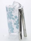 Cubi di ghiaccio in vetro e pinze — Foto stock