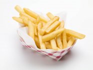 Portion of potato fries in paper dish — Stock Photo