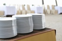 Vista de primer plano de los platos apilados en una mesa buffet - foto de stock
