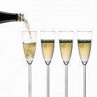 Pouring sparkling wine into glasses — Stock Photo