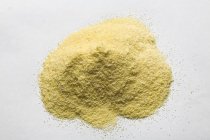 Elevated view of cornmeal heap on white surface — Stock Photo