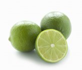 Limes fraîches avec la moitié — Photo de stock