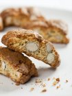 Primo piano vista di pezzi Biscotti con noci su superficie bianca — Foto stock