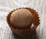 Chocolate truffle on brown wooden table — Stock Photo