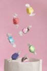 Vue rapprochée des bonbons tombant dans un sac en papier — Photo de stock