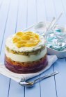 Trifle with mango and passion fruit over wooden surface with towel — Stock Photo