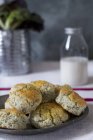 Poppy-seed scones on plate and milk — Stock Photo