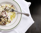 Vista dall'alto d'insalata parzialmente mangiata su un piatto con una forchetta — Foto stock
