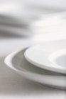 Closeup view of stacked white plates — Stock Photo