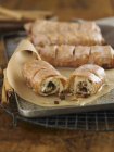Closeup view of cinnamon rolls with raisins and sugar glaze on paper — Stock Photo