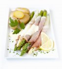 Asparagus wrapped in ham — Stock Photo