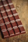 Barra de chocolate na mesa de madeira — Fotografia de Stock