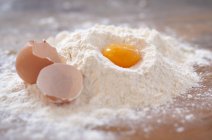 Egg in mound of flour — Stock Photo
