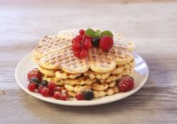 Waffles with raspberries and redcurrants — Stock Photo