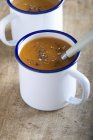 Carrot soup with coriander in mugs — Stock Photo
