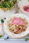 Cabbage Salad Topped with Sliced Variegated Beets; On a Table with a Basket of Flowers — Stock Photo