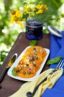 Pan Fried Yellow Tomatoes with Pistachio Caper Relish; On a Platter on an Outdoor Table — Stock Photo