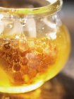 Honey with honeycomb in jar — Stock Photo