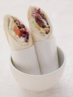 Wraps gefüllt mit Humous und Tomaten im weißen Topf — Stockfoto