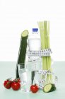Gemüse und Wasser mit Maßband auf weißem Hintergrund — Stockfoto