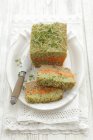 Carrot and broccoli pt with soy and cress on white plate over towel — Stock Photo