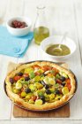 Puff pastry tart with tomatoes, leek, olives and basil pesto  over wooden surface — Stock Photo