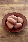 Red potatoes on enamel plate — Stock Photo