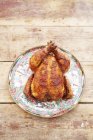Whole roasted chicken on ceramic dish — Stock Photo
