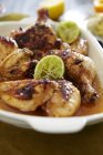 Closeup view of chicken with sambal and limes — Stock Photo
