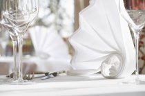 Nahaufnahme gefalteter weißer Servietten auf einem gedeckten Tisch — Stockfoto
