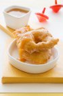 Closeup view of Sfenj deep-fried yeast pastry with sweet sauce — Stock Photo