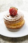 Vue rapprochée de tourbillon de pâtisserie avec glaçage au sucre et une fraise — Photo de stock