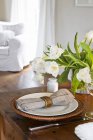 Stillleben mit einem Bund weißer Tulpen in einer Glasvase und einem Platz mit einem Korbteller — Stockfoto