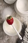 Yoghurt on spoon with strawberry — Stock Photo