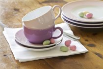 Piatti e tazze impilati con uova di zucchero color pastello — Foto stock