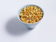 Elevated view of yellow dry pea halves in a bowl — Stock Photo