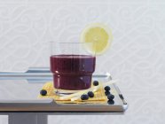 Closeup view of drink with blueberries and lemon slice — Stock Photo