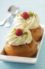 Closeup view of rum babas with whipped cream and raspberries — Stock Photo