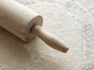 Vue rapprochée de la pâtisserie déployée avec rouleau à pâtisserie et farine — Photo de stock