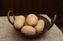 Raw Idaho Potatoes in Old Wok — Stock Photo