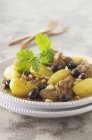 Vista close-up de cordeiro Tagine com batatas, azeitonas e pinhões — Fotografia de Stock