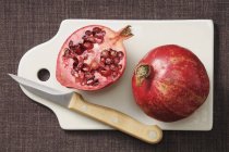 Whole pomegranate with half — Stock Photo