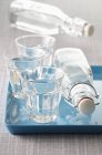 Closeup view of three glasses and two bottles of water — Stock Photo