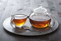 Chá em copo de vidro e bule de chá — Fotografia de Stock