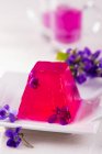 Violet jelly decorated with flowers — Stock Photo