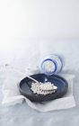 Perle di Tapioca che si riversano da una bottiglia in una ciotola poco profonda con un cucchiaio — Foto stock
