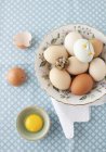 Eggs in Bowl with cracked egg — Stock Photo