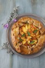 Closeup top view of peach Crostata and flowers — Stock Photo